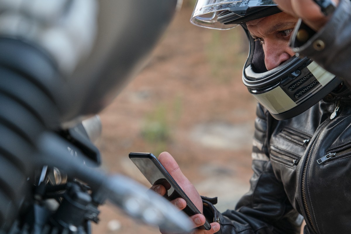 Chiamata d'urgenza da parte di un motociclista. Motociclista effettua una chiamata di emergenza dal suo cellulare.