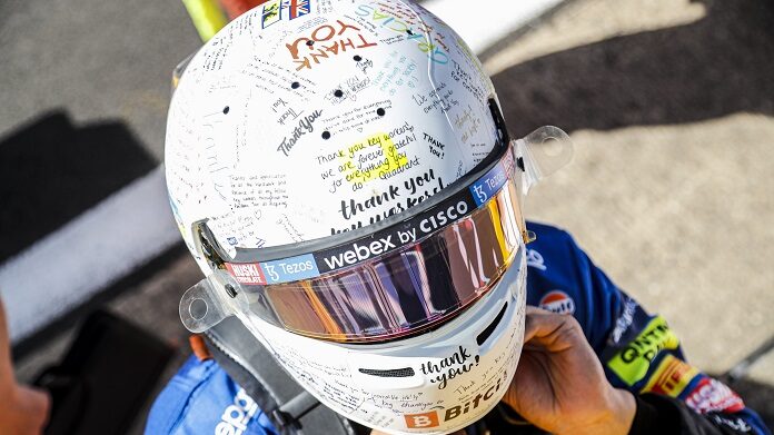 Lando Norris, McLaren, wears a crash helmet adorned by messages