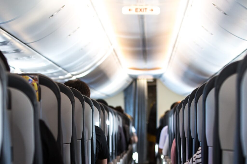 Corridoio interno di un aereo tra le file di sedili