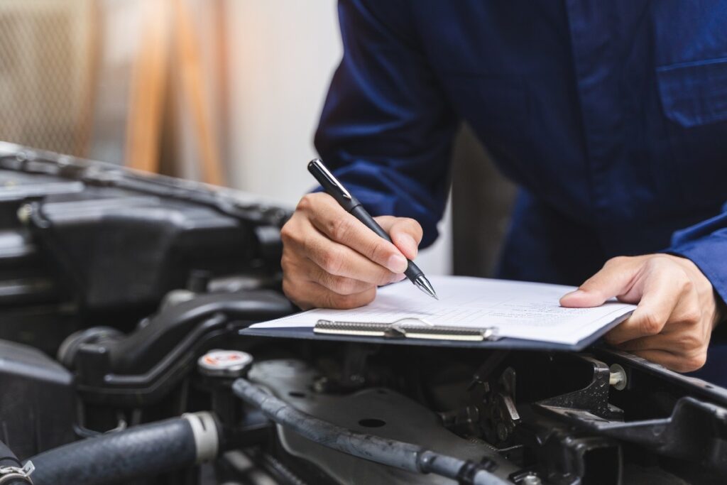 Meccanico che compila la check-list dopo aver controllato l’auto.