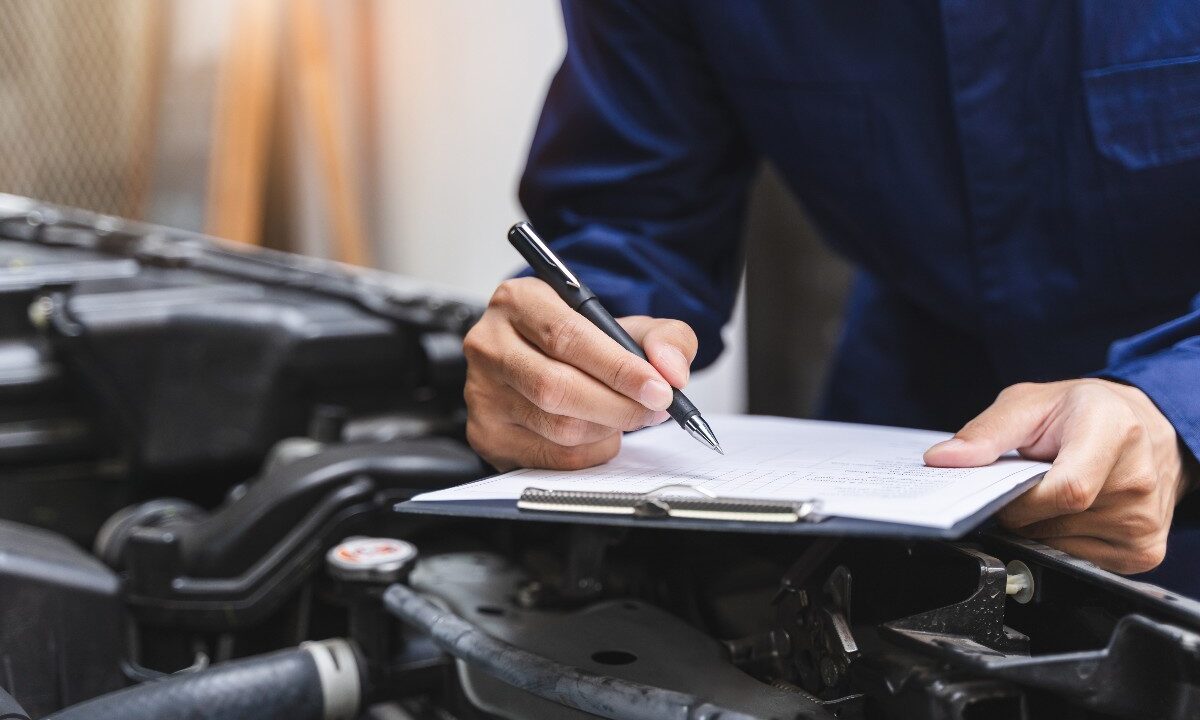 Meccanico che compila la check-list dopo aver controllato l’auto.