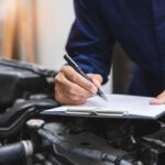 Meccanico che compila la check-list dopo aver controllato l’auto.