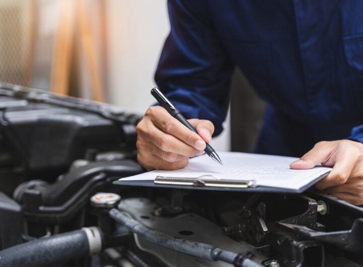 Meccanico che compila la check-list dopo aver controllato l’auto.